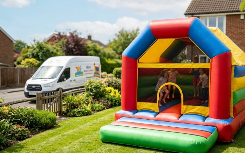 Clean, well maintained bouncy castle set up in a garden with a branded hire van parked nearby